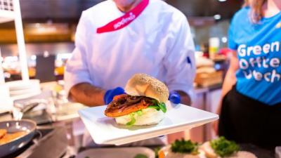 Kok toont een hamburger op een wit bord
