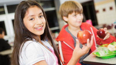 Twee kinderen houden een appel vast
