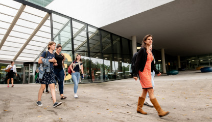 Mensen lopen een universiteitsgebouw in en uit