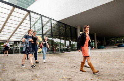 Mensen lopen een universiteitsgebouw in en uit