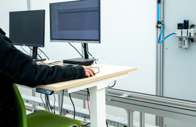Universiteitsmedewerker bedient pc in lab