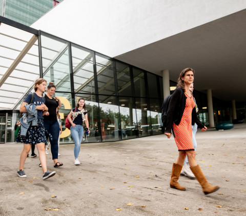 Mensen lopen een universiteitsgebouw in en uit