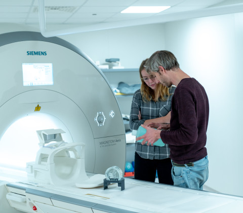 twee medewerkers naast een MRI-scanner